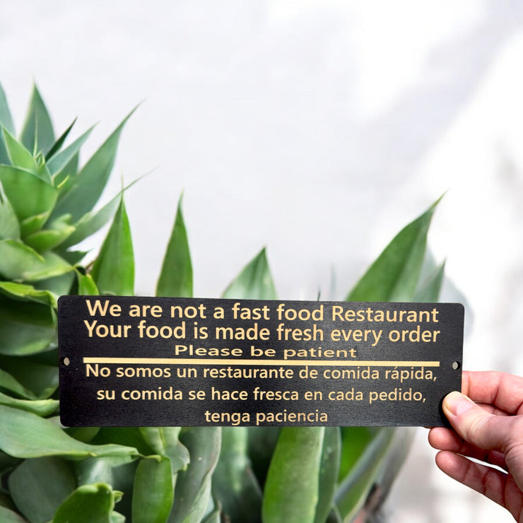 Sign - English & Spanish - We are not a fast food restaurant Please Be Patient